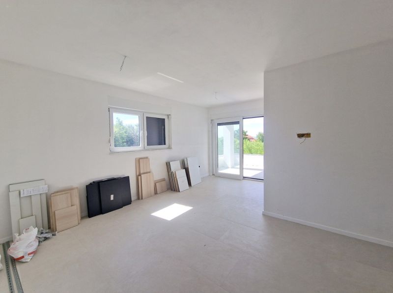 A bright room with large windows, tiles, and prepared materials in a 3-room apartment.