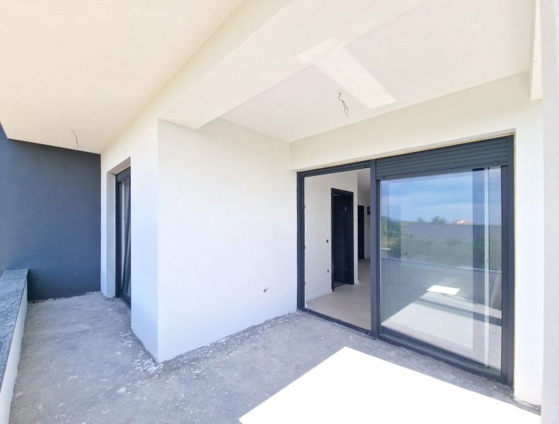 A balcony in a 3-room apartment in Privlaka with large sliding windows.