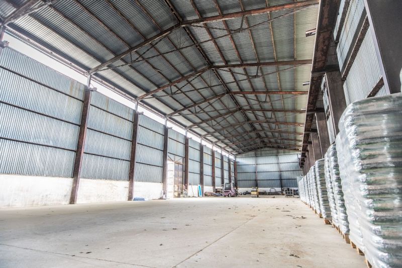 Warehouses and halls in Dulov with metal roofs and stored materials inside.
