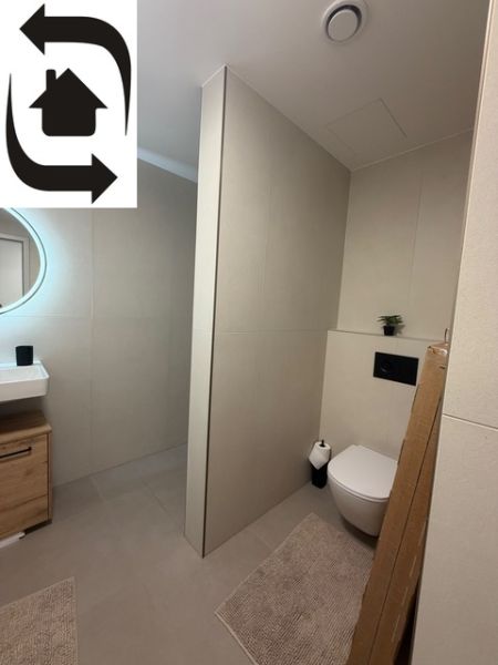 Bathroom in a 2-room apartment with a sink, shower, and toilet.