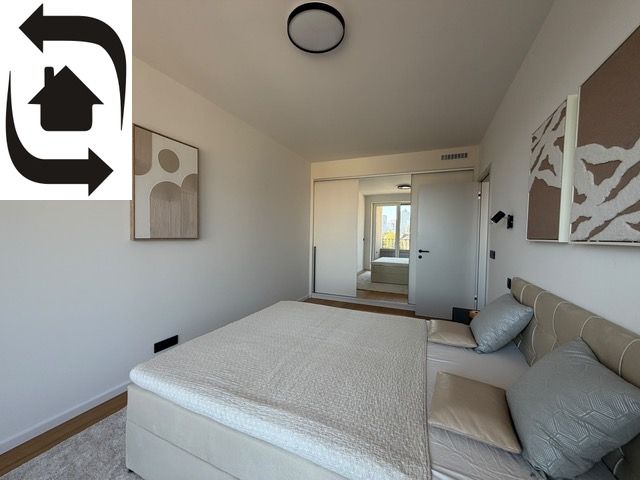 A bedroom in a two-room apartment with a wooden decor floor, cozily furnished.