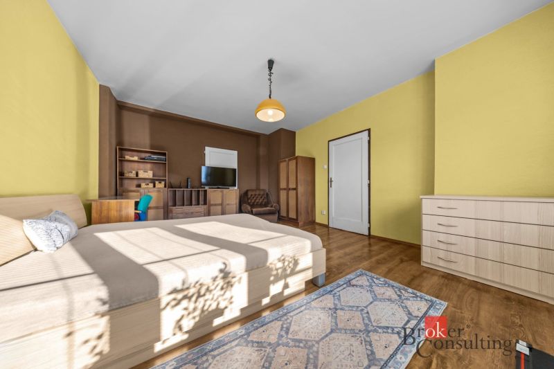Bedroom in a 3-room apartment with wood-decor flooring, cabinets, and a TV stand.