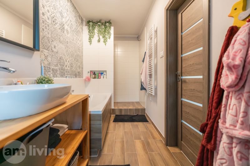 Bathroom in a 3-room apartment with a wooden decor floor and tiles with ornaments.