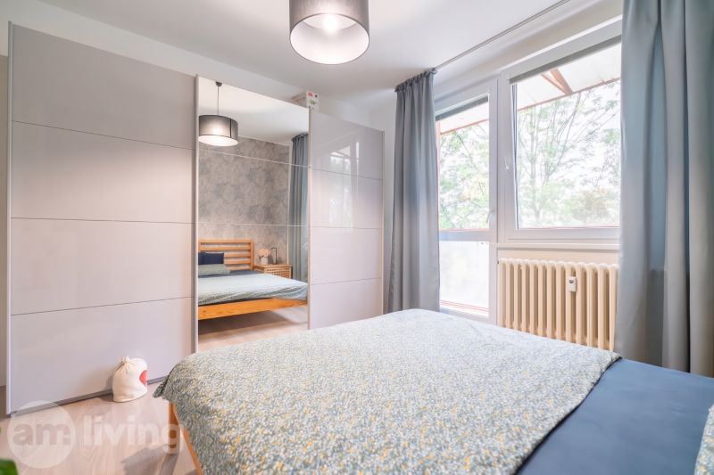 Bright bedroom with a wardrobe, bed, and window, suitable for a 3-room apartment.