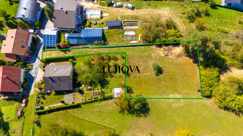 A residential plot on Sládkovičova Street in Považská Bystrica surrounded by nature and houses.