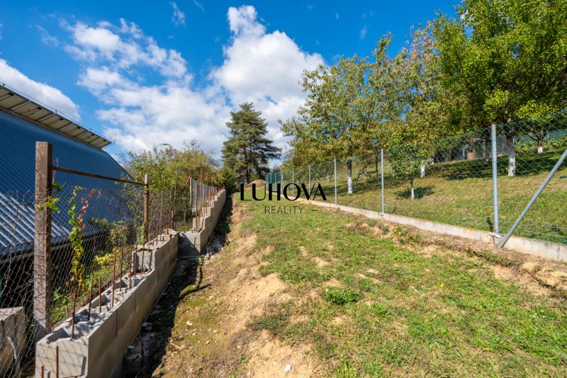 Grassy slope with a fence on Sládkovičova Street in Považská Bystrica, Land - residential.