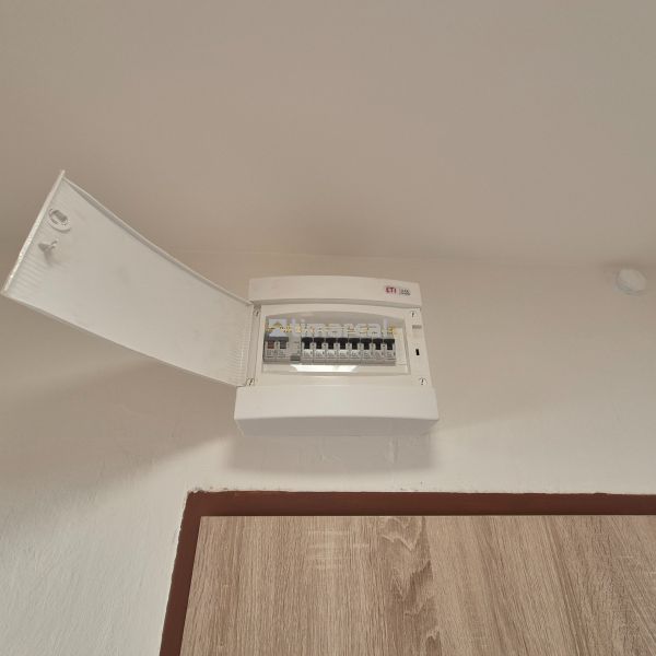 An open distribution box in a studio apartment with a view of the fuses.
