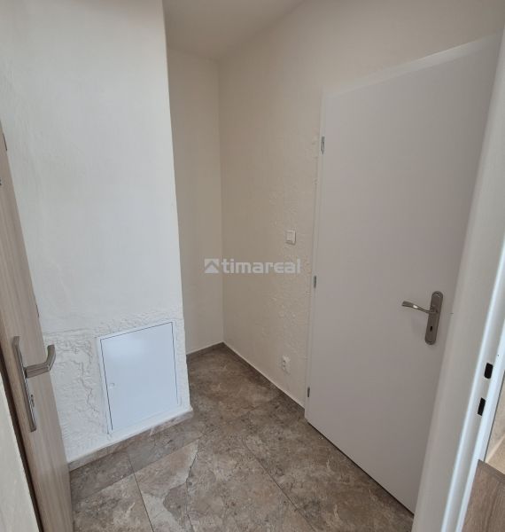 Entrance hall of a studio apartment with tiles and white doors.