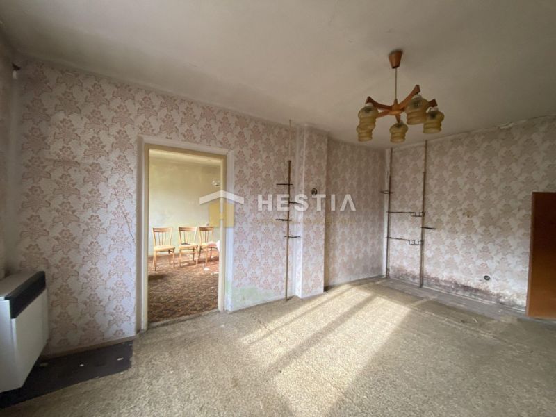 Room with carpet, wallpaper, and a retro chandelier in a family house.
