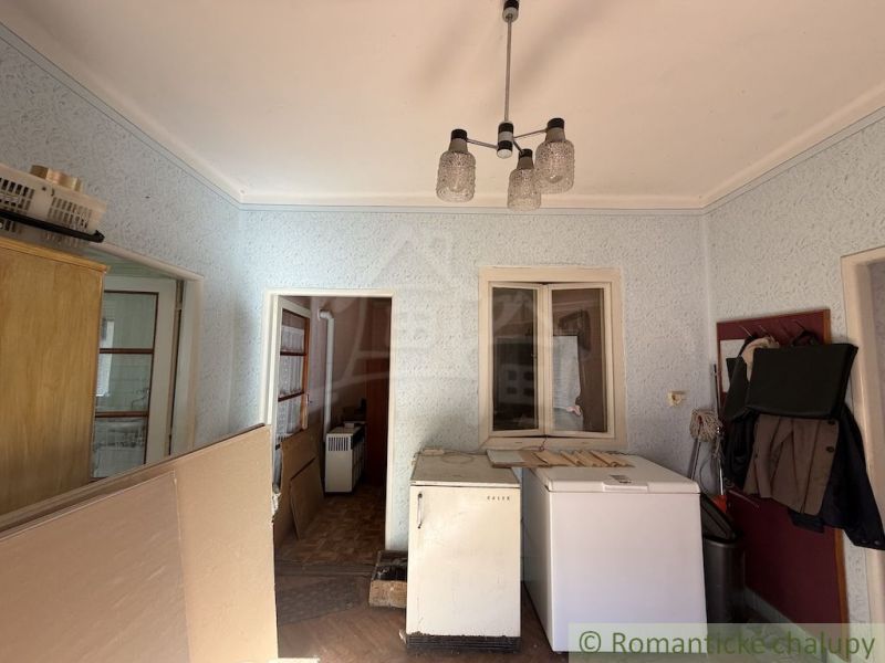 The interior of a family house with cracked plaster and older furniture.