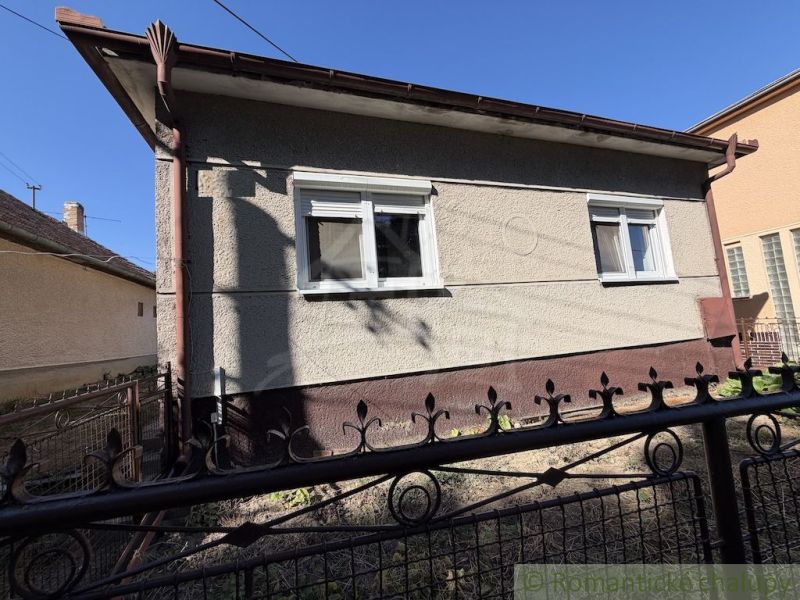 A family house in Tvrdošovce, shown behind an iron fence.
