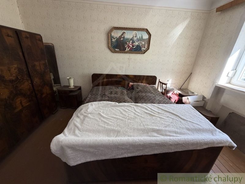 Bedroom in a family house with an antique bed and a painting on the wall.