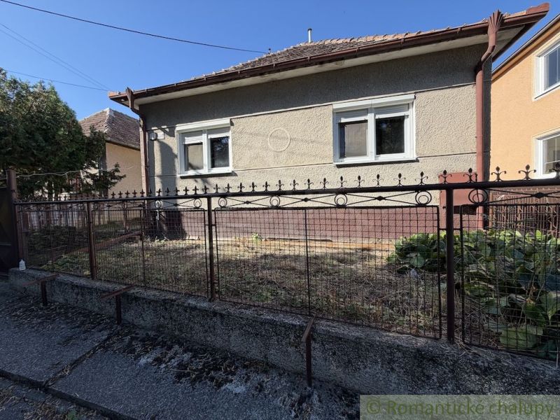A family house in Tvrdošovce with a small front garden and a metal fence.