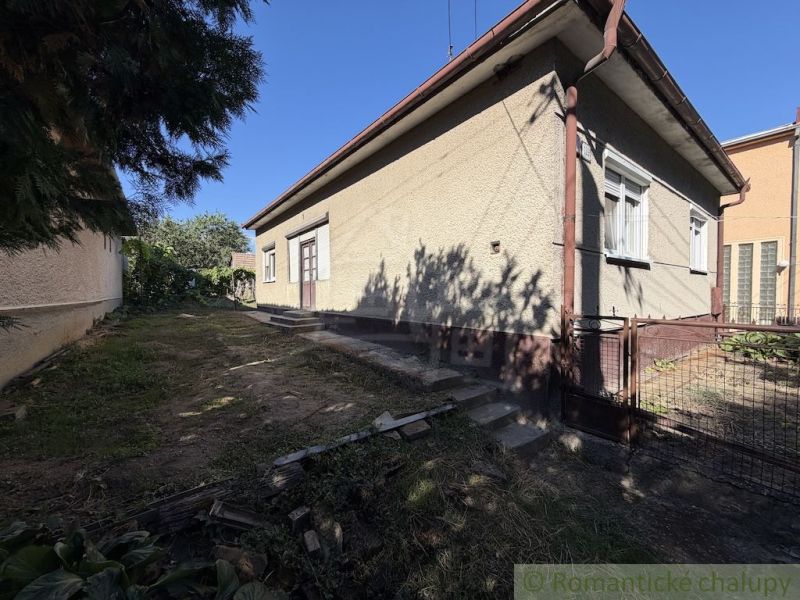 A family house in Tvrdošovce with a grassy plot and a side entrance gate.