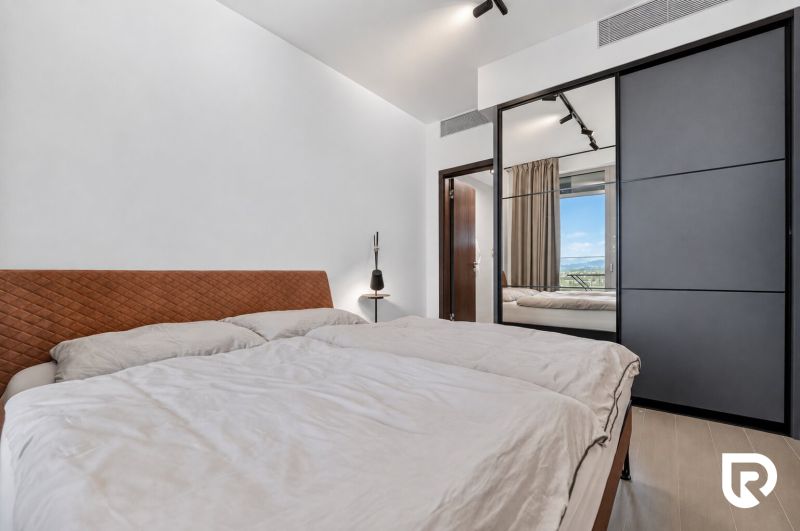Bedroom with a large bed and a wardrobe in a two-room apartment.