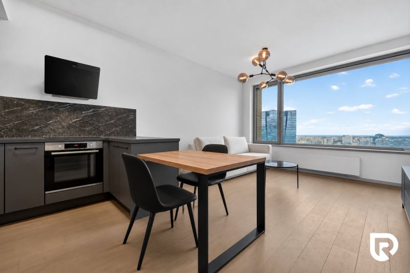 Kitchen with a dining table, sofa, and large window, 2-room apartment.