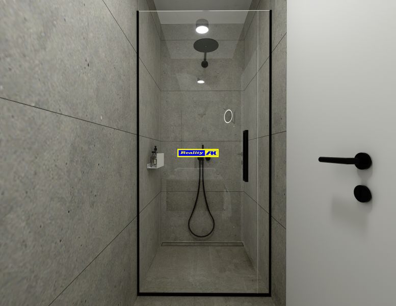A shower corner with gray tiles and black accessories in a 2-room apartment.