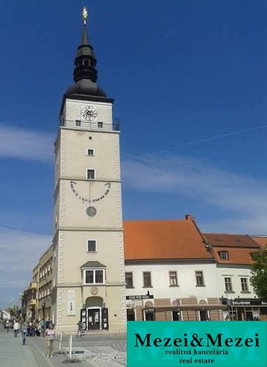 City Tower in Trnava near a 2-room apartment, blue sky, historical character.