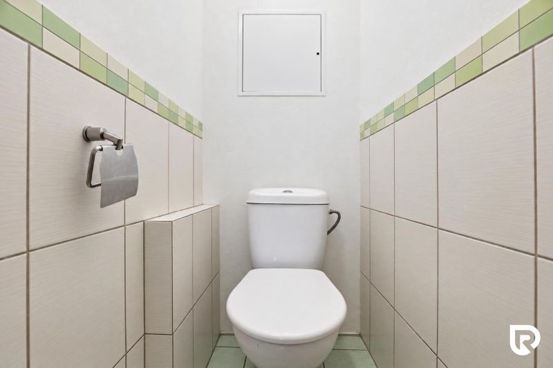 A toilet with simple tiles and light tiles in a 3-room apartment.