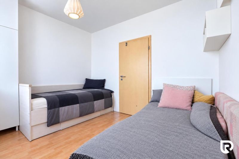 Children's room in a 3-room apartment, two beds, wooden decor flooring, simple furniture.