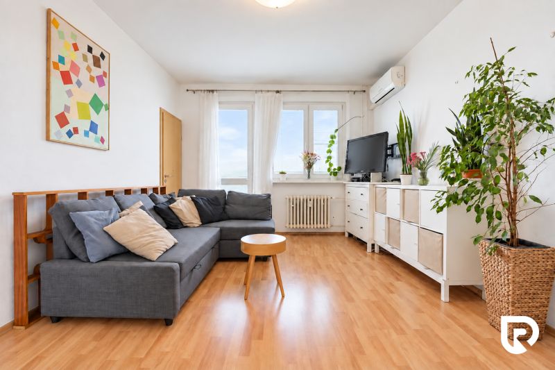 A living room in a 3-room apartment with a wooden decor floor and comfortable seating.