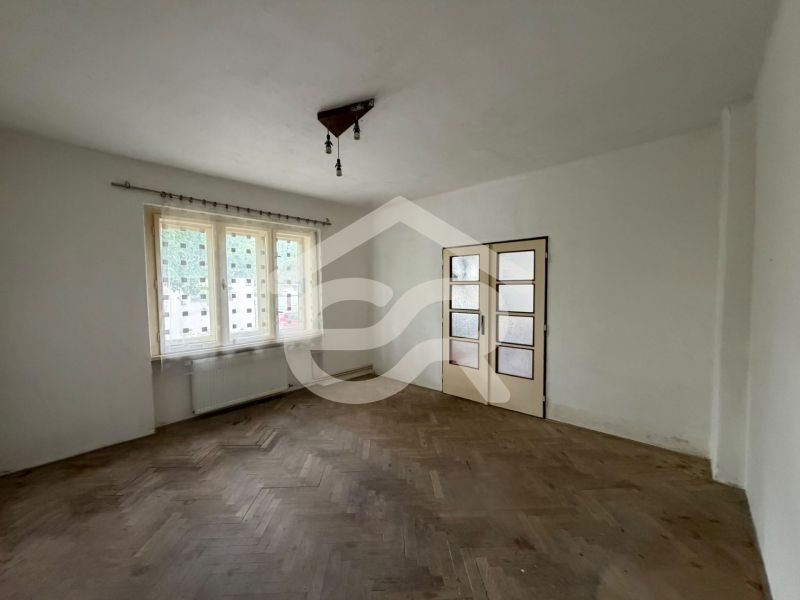 The interior of a family house with white walls and a floor with a wooden decor.
