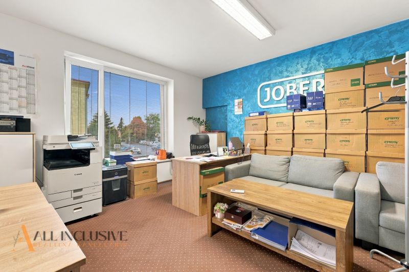 Offices with a sofa, boxes, and a printer, wooden decor flooring, blue wall.