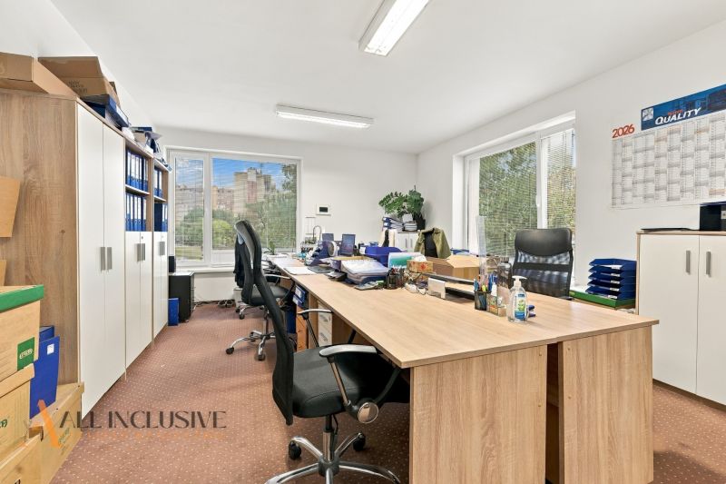 Offices with wood-decor flooring, a large desk, and cabinets full of documents.