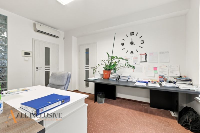 Cozy offices with wall clocks, written papers, and a plant on the side.