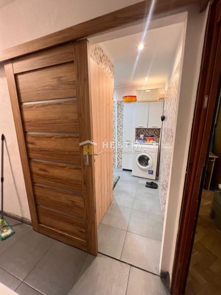 Bathroom in a 3-room apartment with a washing machine and doors with a wooden decor.