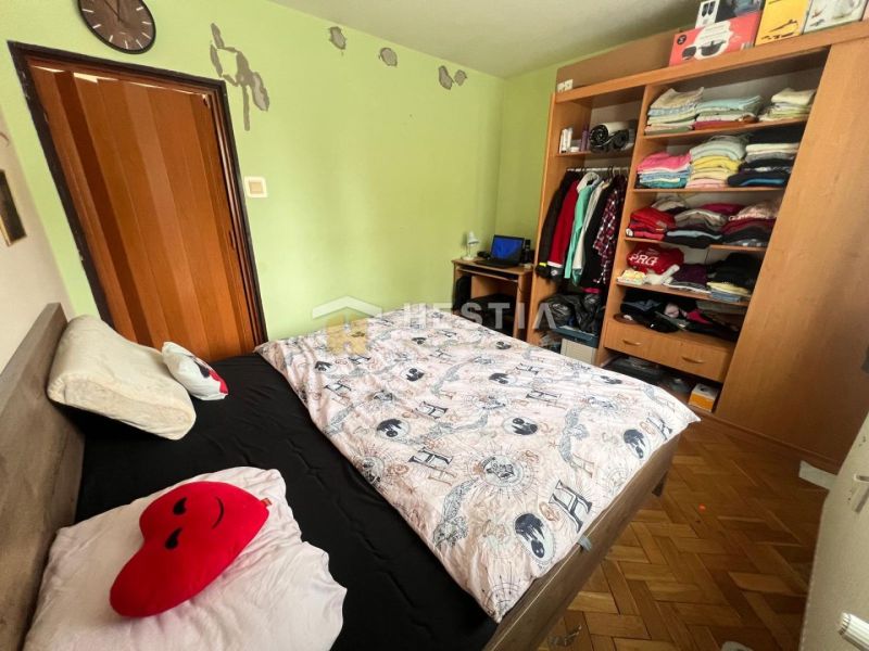 Bedroom with a built-in wardrobe, Paris-themed bedding, and a wooden decor floor.