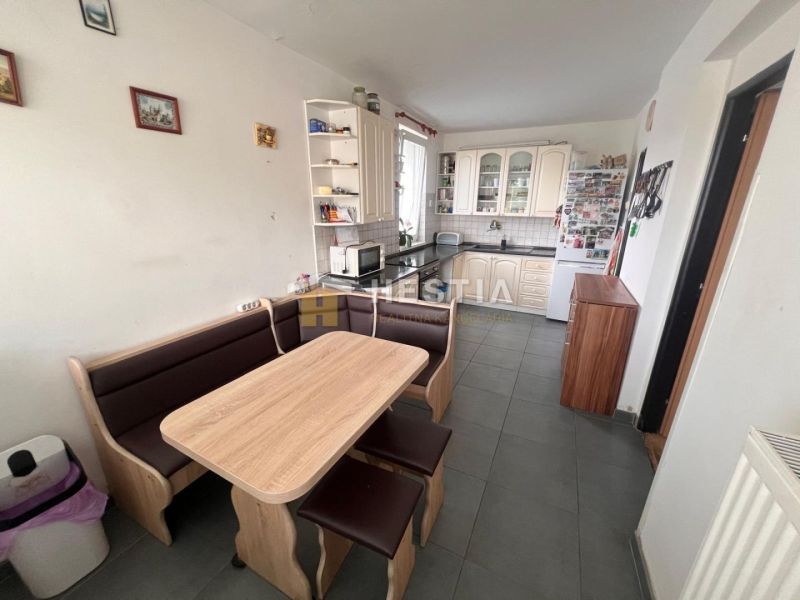 A kitchen in a 3-room apartment with a corner unit, a dining area, and tiles.