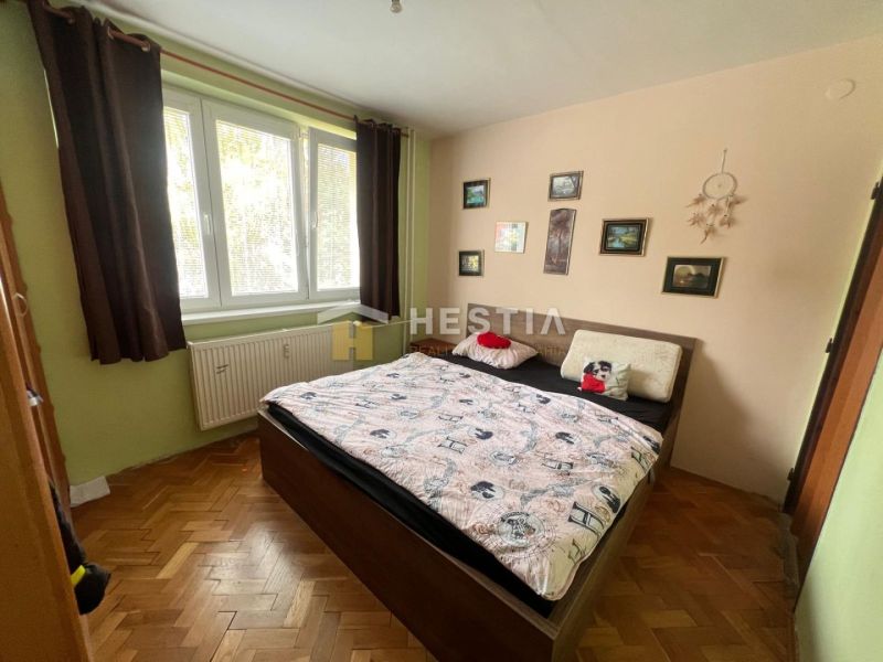 Bedroom with a bed and decorations in a 3-room apartment, floor with wooden decor.