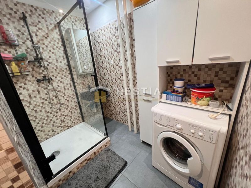 Cozy bathroom with a shower and a washing machine in a 3-room apartment.