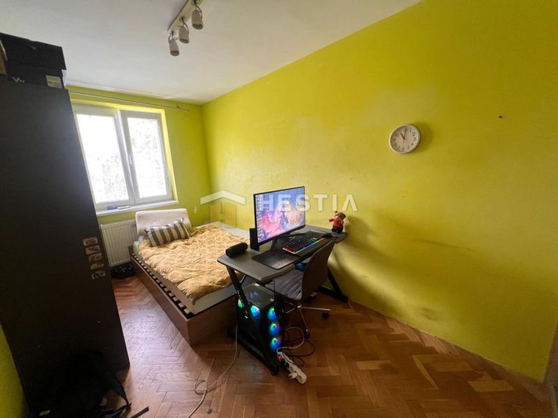 A room in a 3-room apartment with wooden decor and yellow walls.
