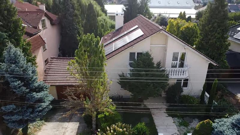 A family house in Trenčianske Stankovce surrounded by greenery, with solar panels on the roof.