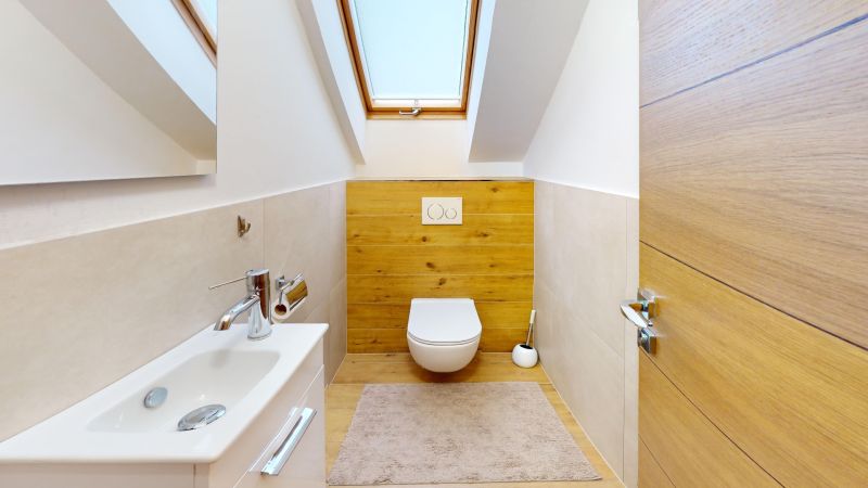 A bathroom in a family house with a wooden decor floor and a skylight.