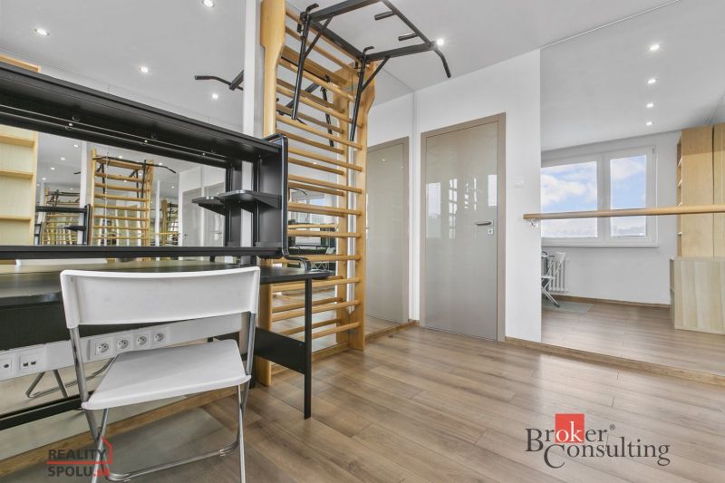 Interior of a 5 or more room apartment with a wooden decor floor and gymnastic wall bars.