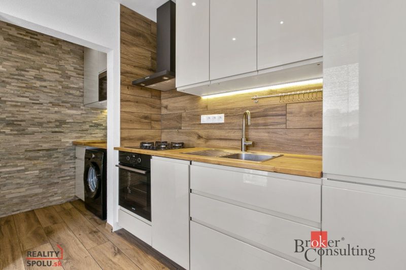 A kitchen with a wooden decor floor in a 5 or more room apartment, modern equipment.