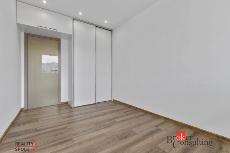 A room in a 5 or more bedroom apartment with a wood-decor floor and a built-in wardrobe.