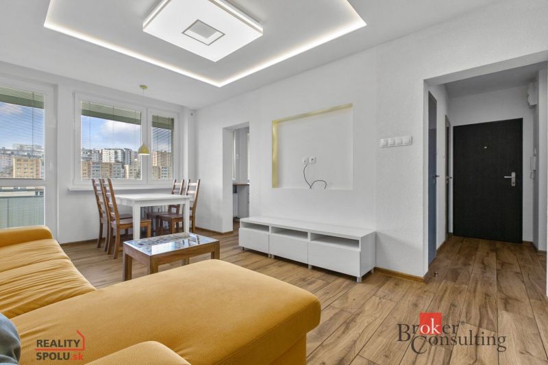 A living room in a 5 or more room apartment with a sofa and a wood-patterned floor.