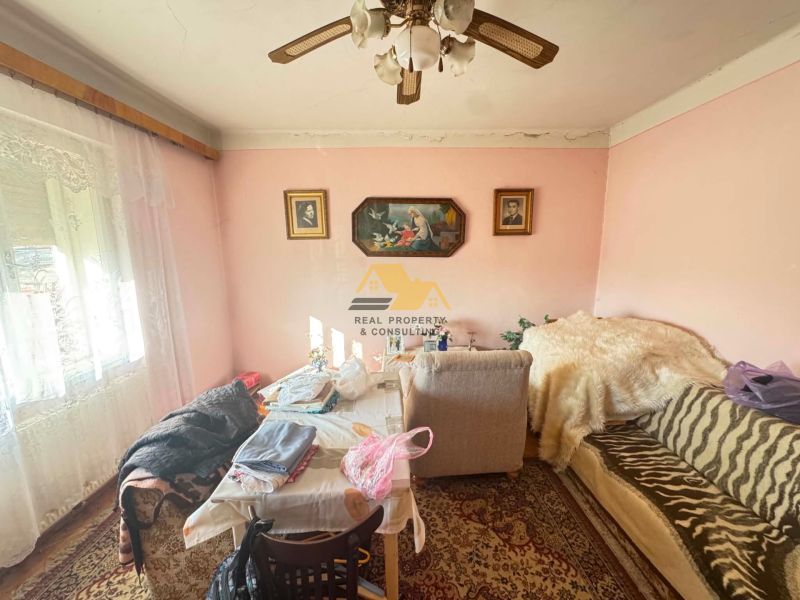 Living room in a family house with a couch, table, and paintings on the walls.