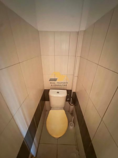A toilet with beige tiles in a family house.