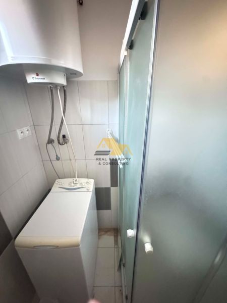 Compact bathroom in a family house with a shower and a washing machine.