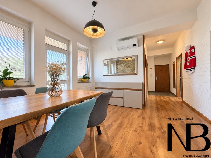 Dining room in a 3-room apartment with wood-patterned flooring and stylish lighting.