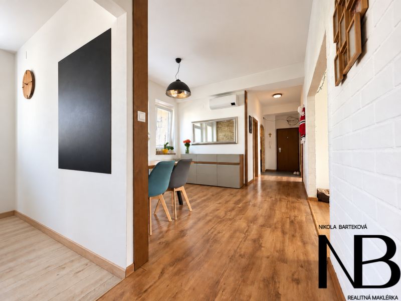 Interior with wood-patterned flooring, showing an entrance hallway and dining area in a 3-room apartment.