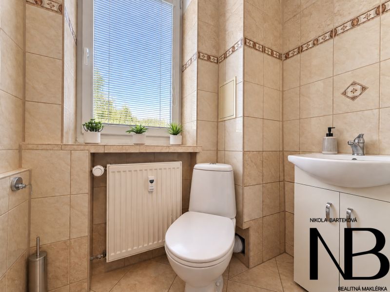 Bathroom in a 3-room apartment with ceramic tiles, toilet, and sink.