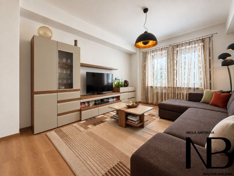 Living room in a 3-room apartment with a wooden decor floor and a comfortable sofa.
