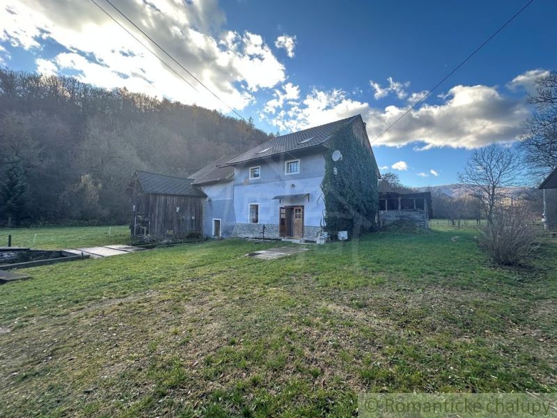 A family house in Mokrá Lúka surrounded by nature, green lawn, blue sky.