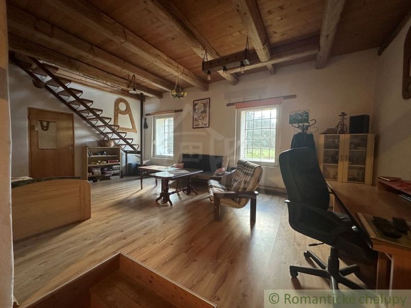 Interior of a family house with a wooden decor floor, stairs, and a wooden ceiling.